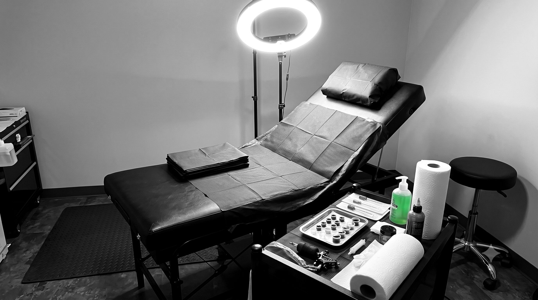 The studio's private tattoo station, with a ring light, sterile ink caps and equipment laid out for a session